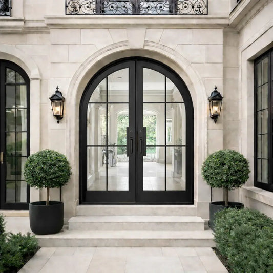 Luxurious home entrance with black arched door and decorative elements.